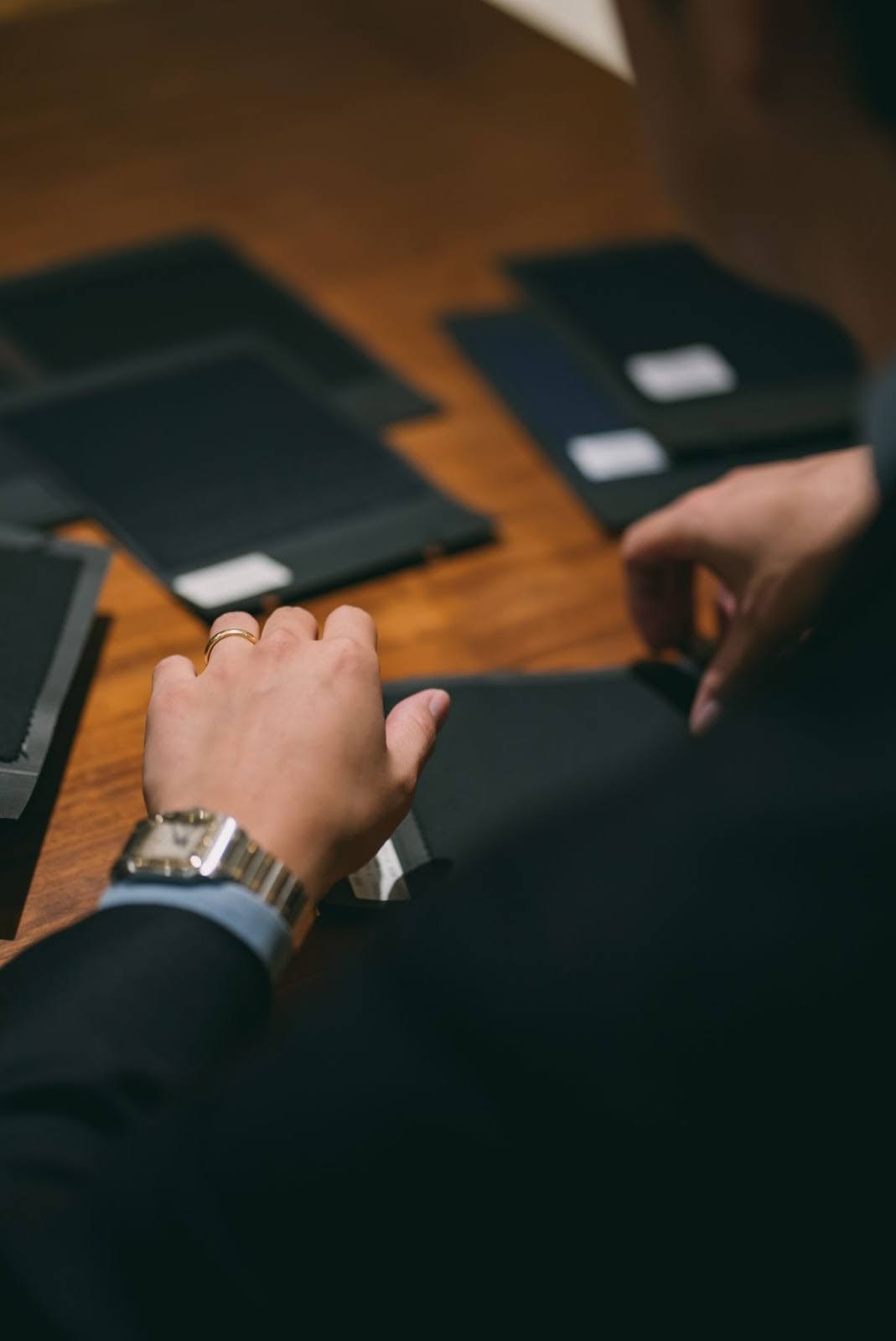 生地を選ぶ"コーディネート中のメンズフォーマルコーディネーターの多和勇貴(たわゆうき)"