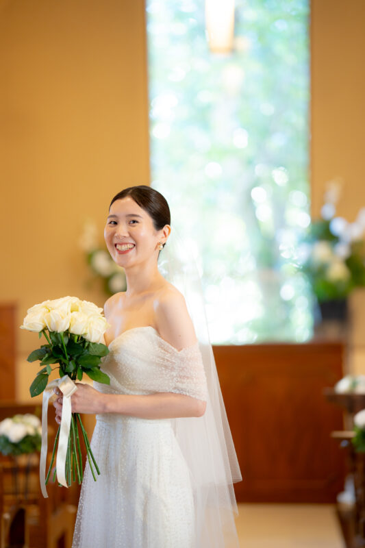 ハーフペニーロンドンのチュールでオフショルダーのウェディングドレスに、トリート神戸店がコーディネートした透明感のあるベールを纏って過ごす挙式