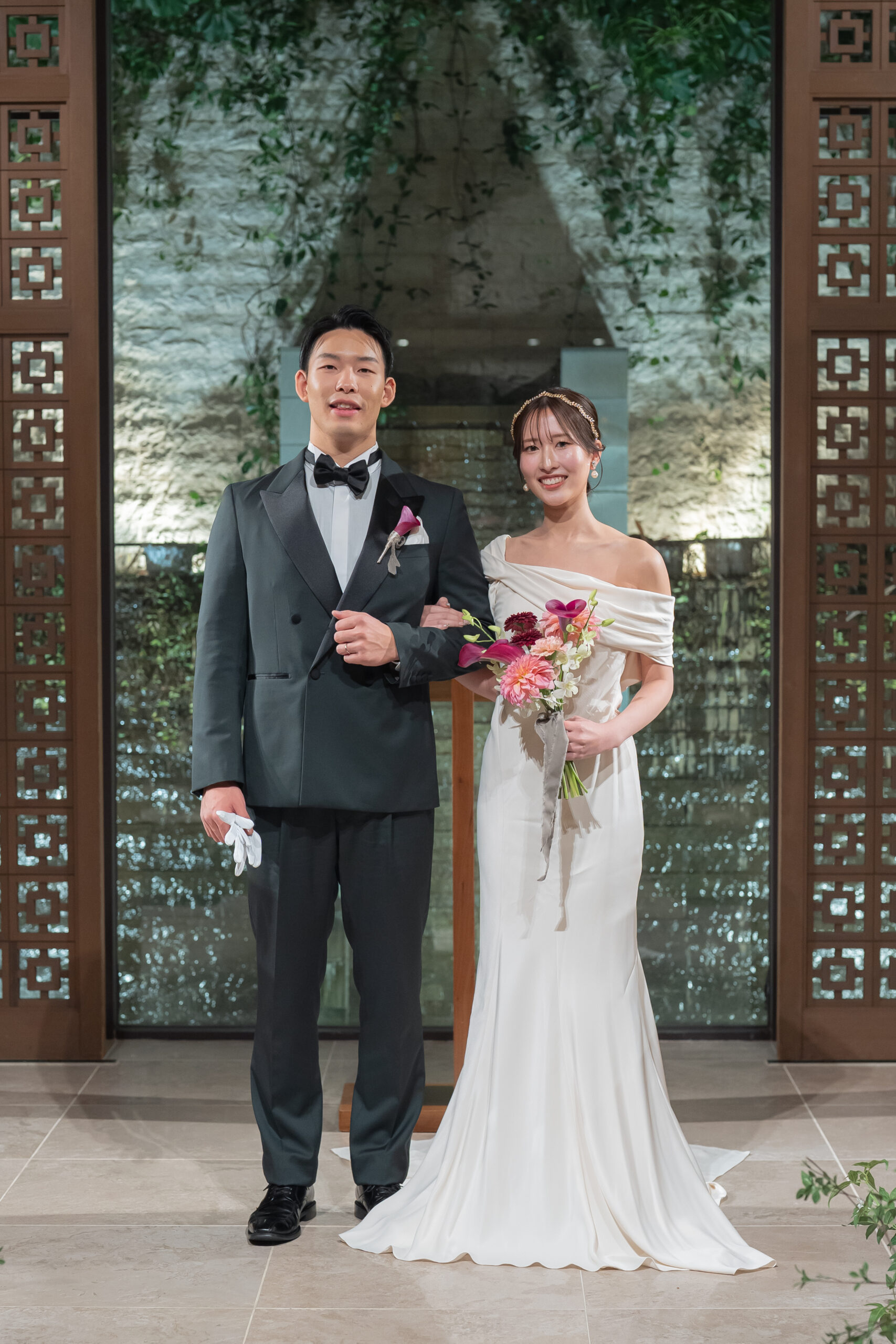 ウィズ ザ スタイル フクオカのチャペルでのお写真。トリート ジェントルマンのタキシードをお召頂いたご新郎様と、モニーク ルイリエのドレスを身に纏われたご新婦様のお写真。