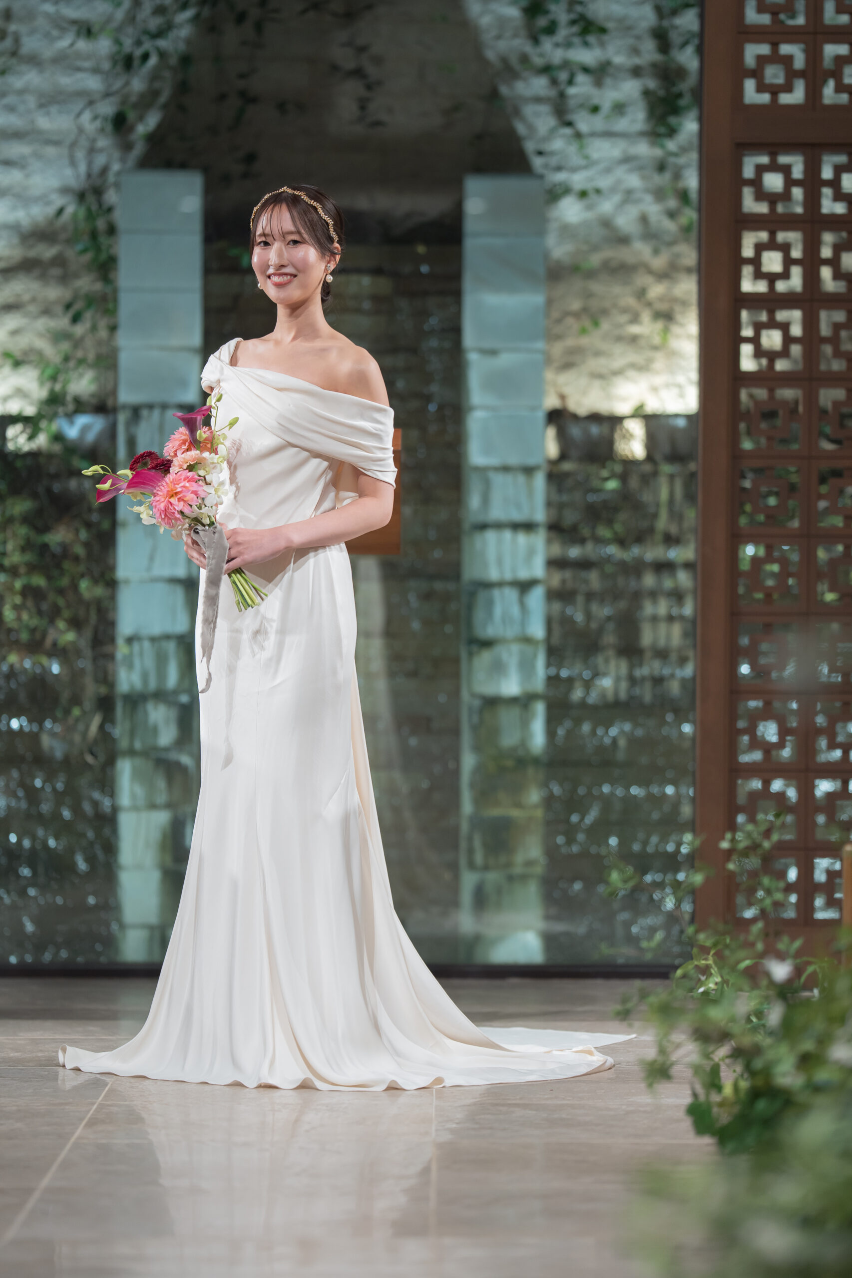 ウェディングドレスを身に纏われチャペルでお撮りした一枚。 モニーク ルイリエのウェディングドレスは、女性のボディラインを美しく魅せるため、緻密に計算し尽くされたデザインばかり。   ご新婦様の本来持つ美しいスタイルを、シンプルなウェディングドレスがより一層引き立てます。さらに、ワンショルダーのデザインが、女性らしさや華やかさの中にモダンさやさりげない遊び心をプラス。