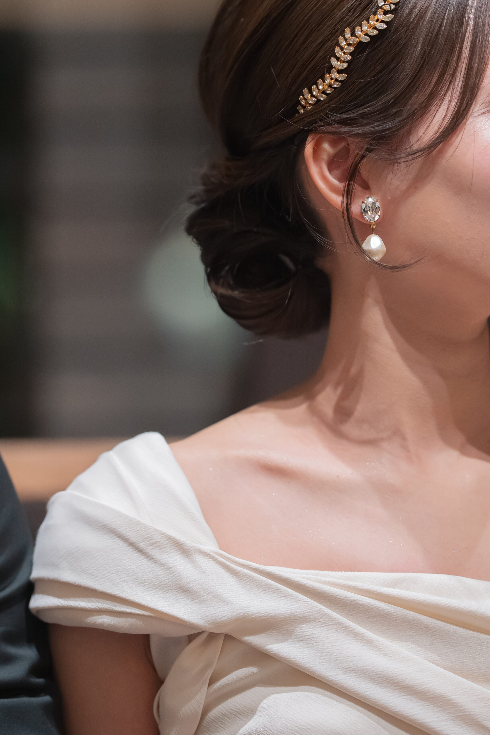 新婦様がつけているアクセサリーの写真。 耳元には、一粒で美しく輝くイヤリングを添えて可憐な印象に。 ヘッドパーツは、華美になりすぎない華奢なものをセレクトいたしました。