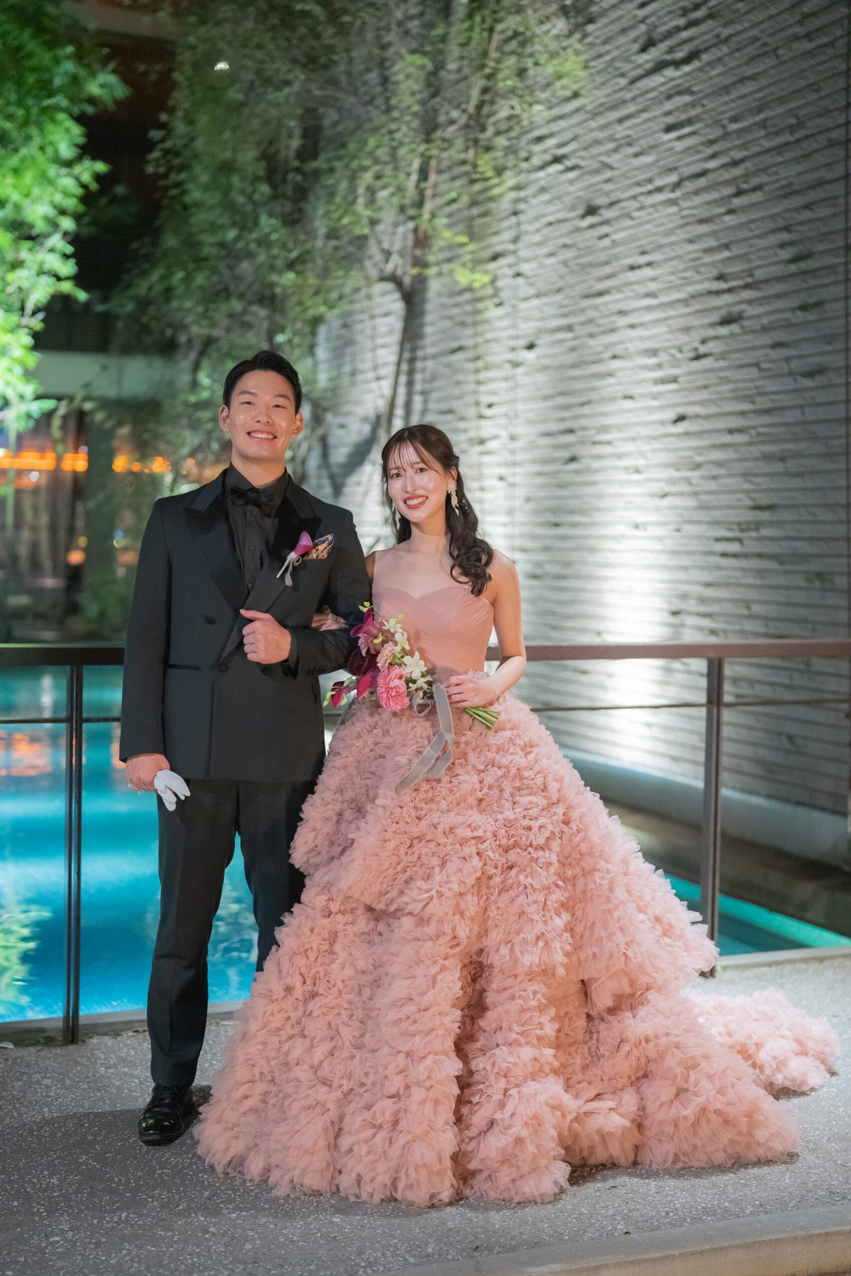 ほんのり柔らかなピンクベージュの色合いは、おふたりが思い描かれていたナチュラルで上質なナイトウェディングの雰囲気とも美しく調和。 ピンクでありながら甘くなりすぎず、落ち着いたニュアンスカラーがご新婦様の上品で大人な魅力を引き立てます。