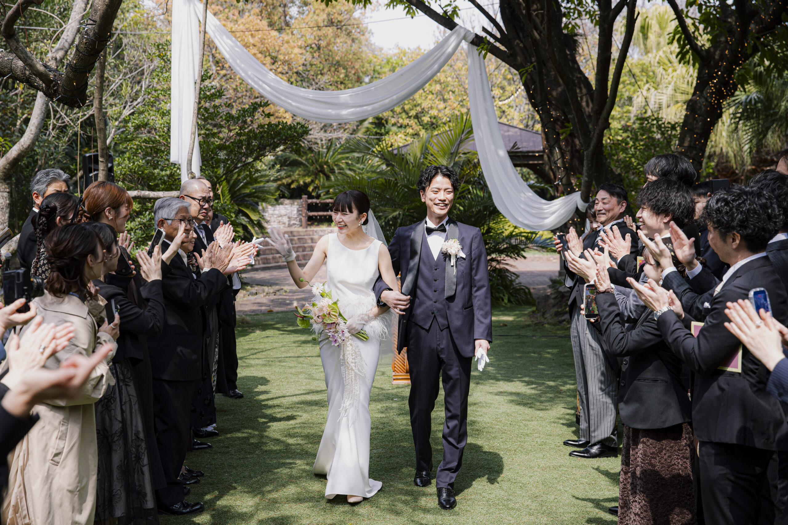 トリート福岡の提携会場のザ ルイガンズ スパ＆リゾートでセレモニーから退場するご新郎ご新婦様。