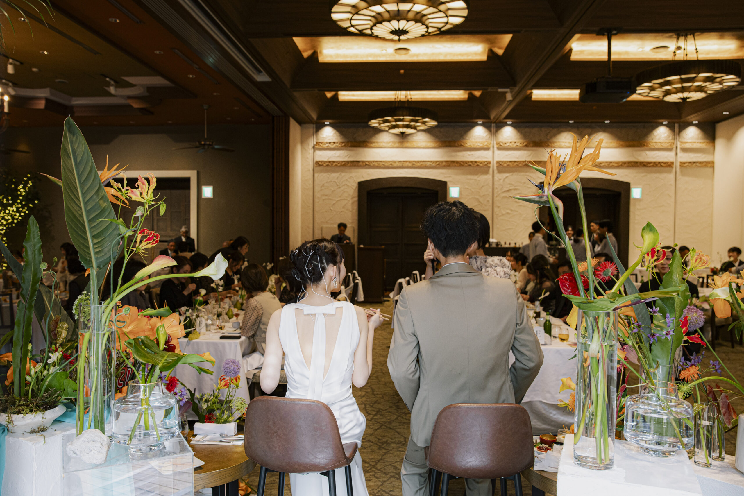 トリート福岡の提携会場のザ ルイガンズ スパ＆リゾートで披露宴を過ごすご新郎ご新婦様の後ろ姿。