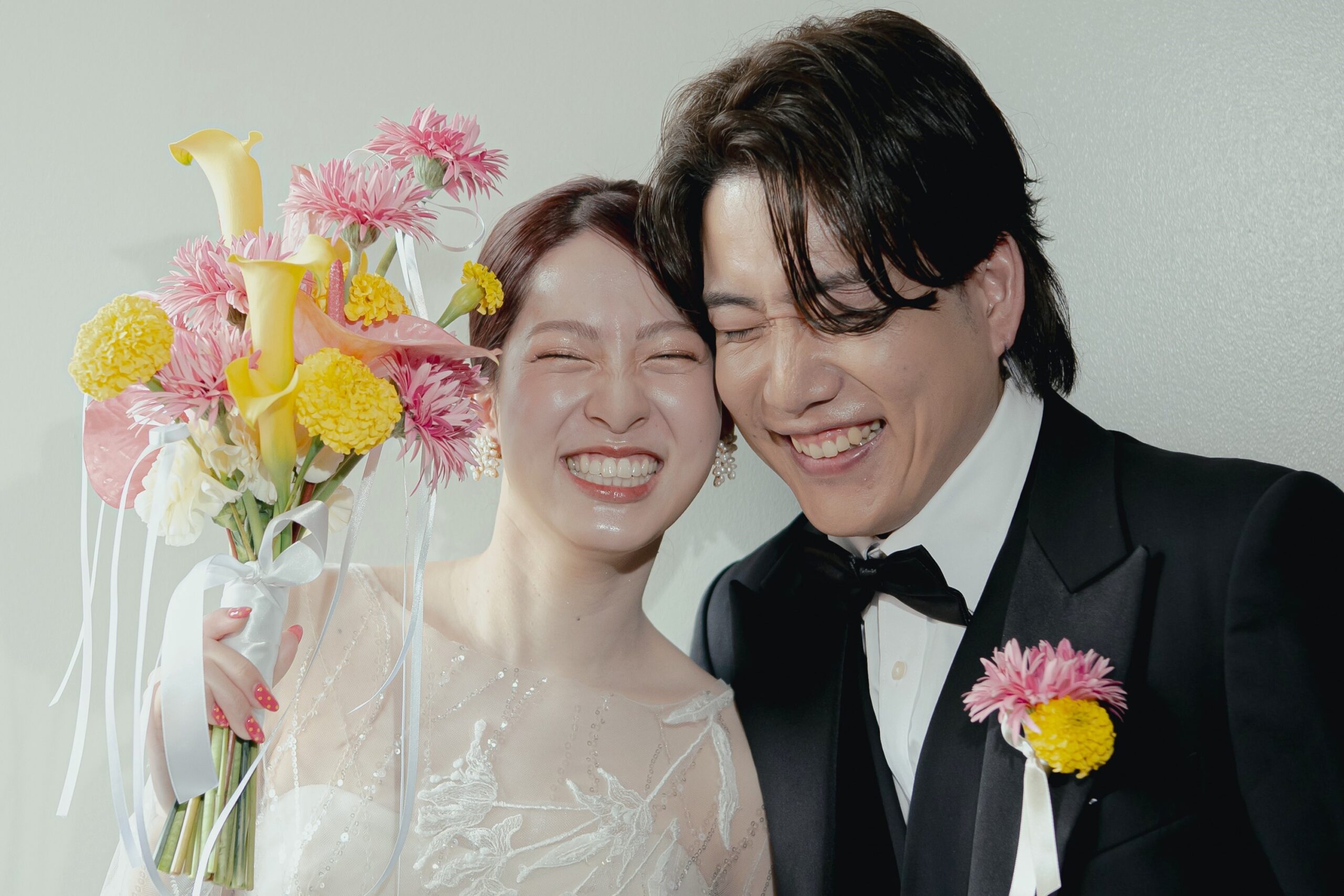 トリートオリジナルのウェディングドレスを身に纏い、頬を寄せて笑いあうご新郎ご新婦様。