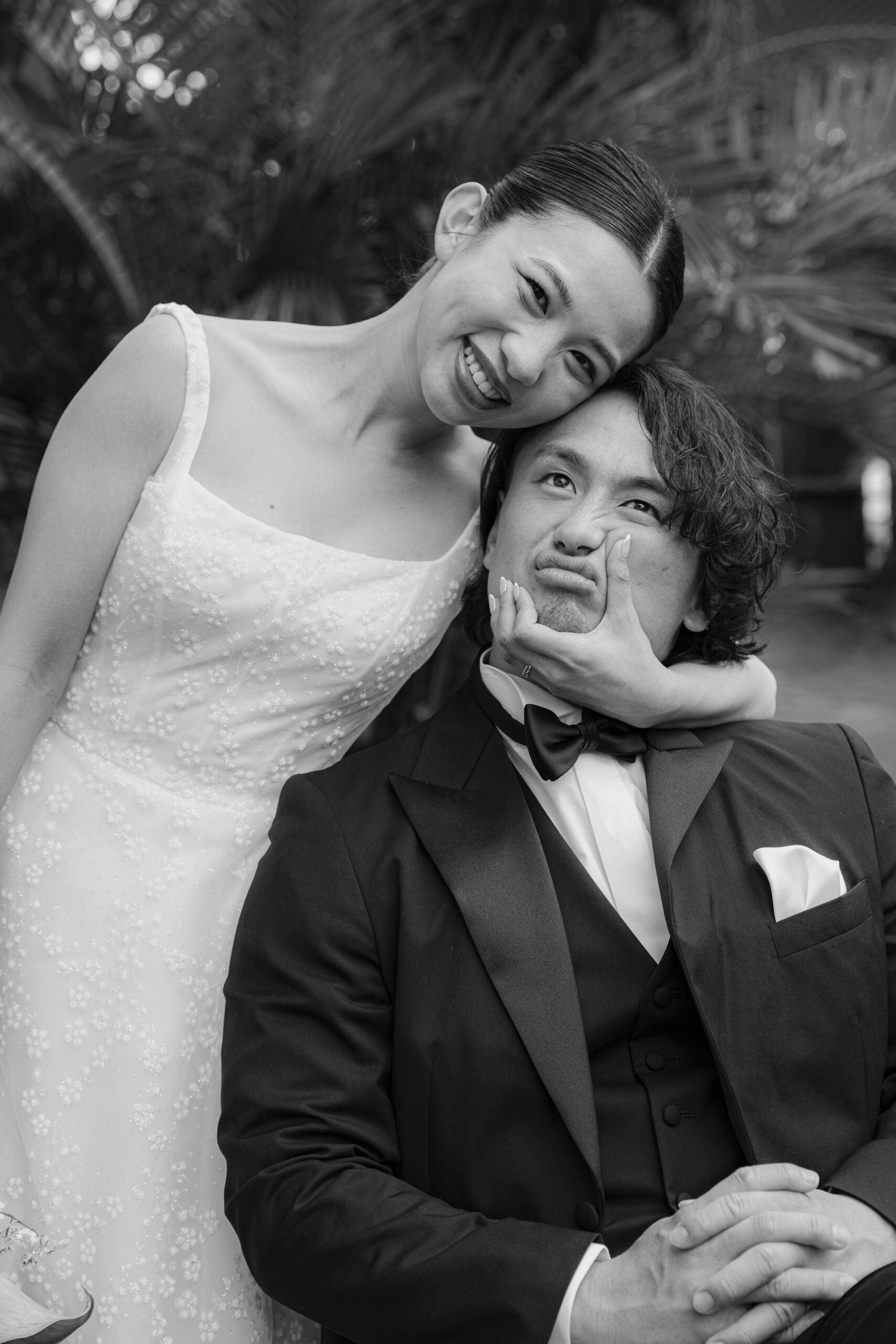 マーク イングラム フォー ヴァレンティーニのウェディングドレスとタキシードを身に纏い、じゃれ合う新郎新婦。