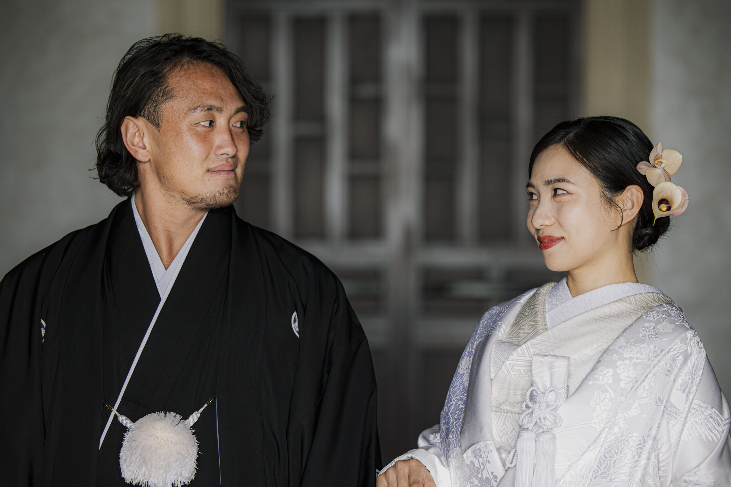 トリート福岡の白無垢と紋付袴姿で顔を見合わせる新郎新婦。