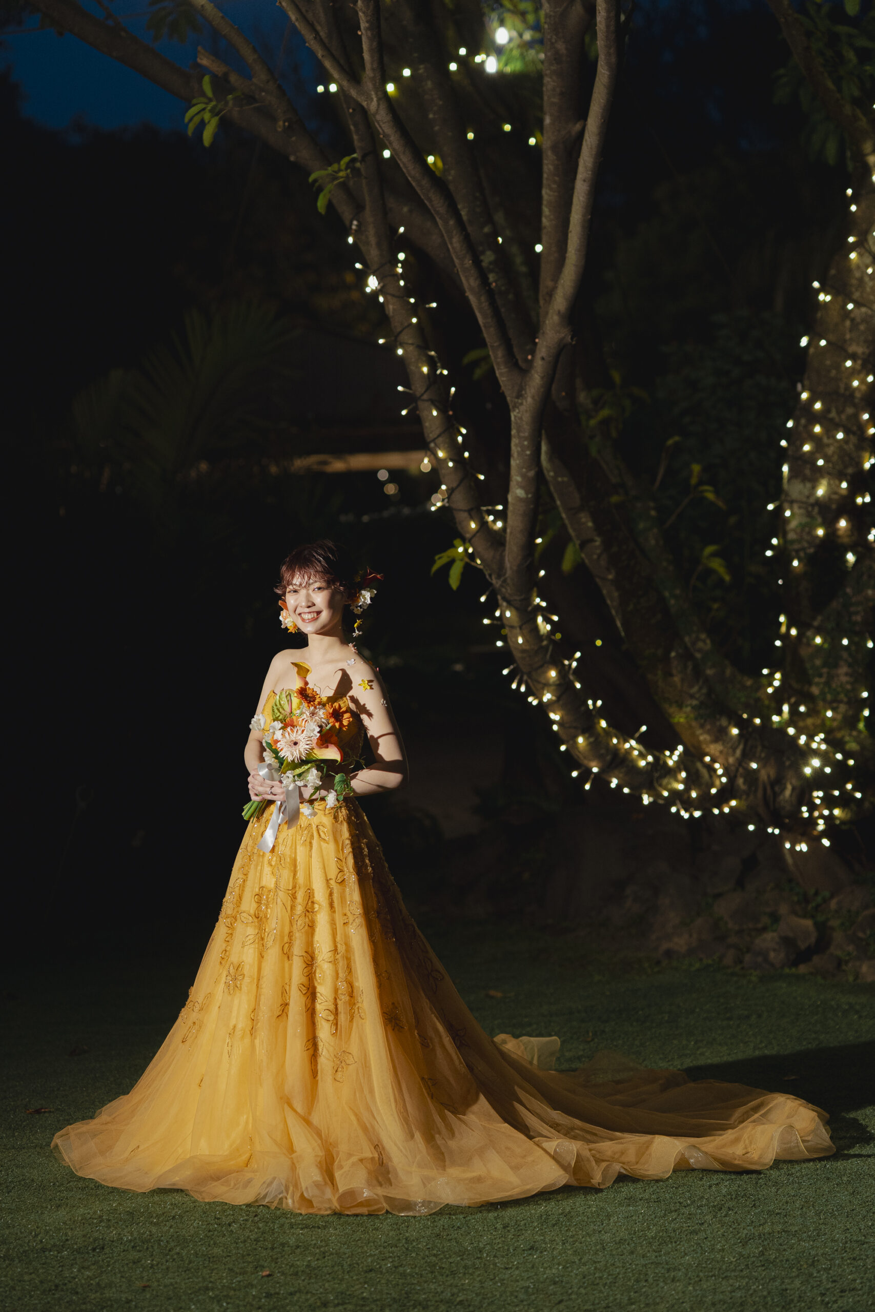 夜、ガーデンでエナウラのカラードレスを着ているご新婦様