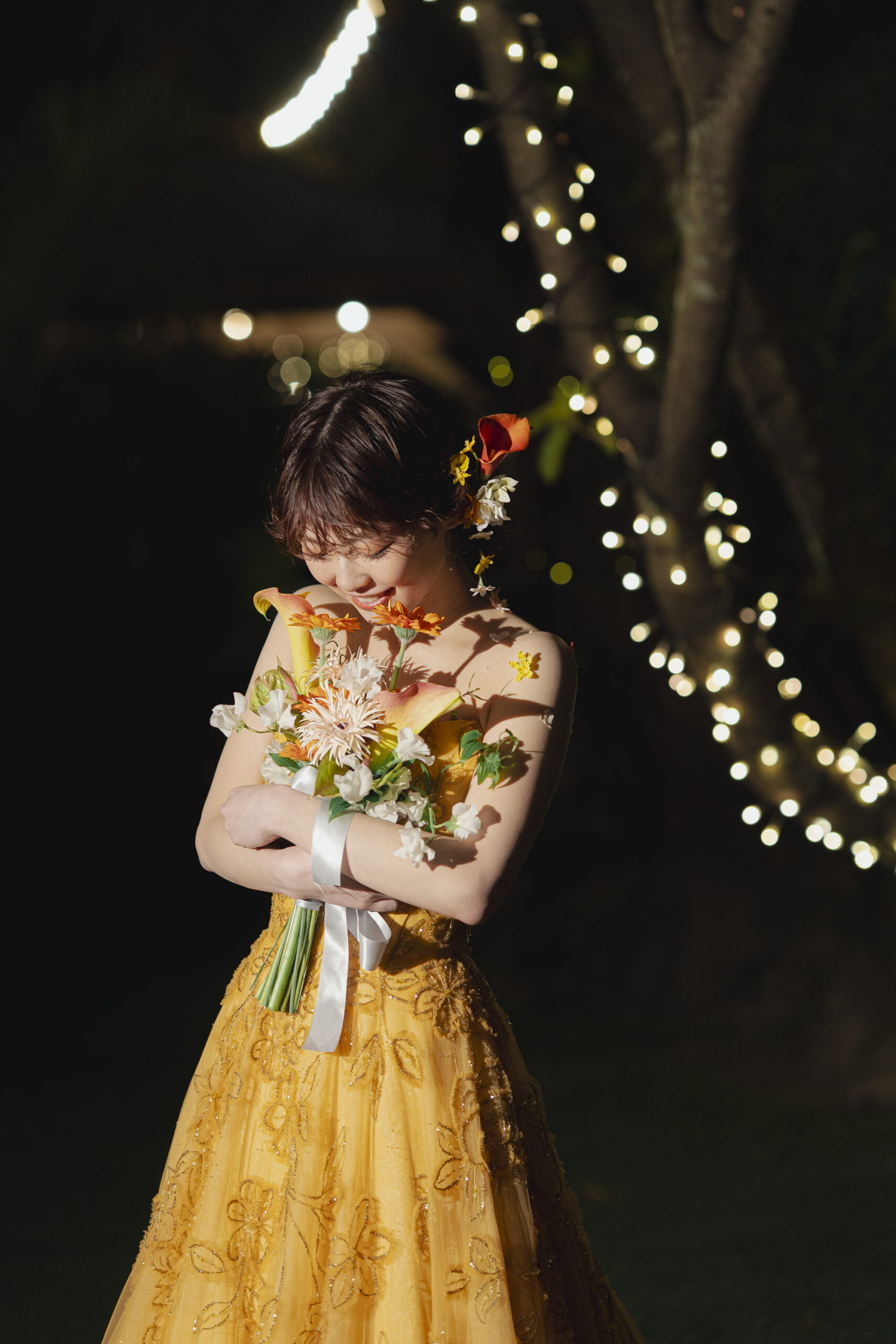 夜のガーデンで、愛おしそうにブーケを抱きしめるエナウラのカラードレスを着用したご新婦様