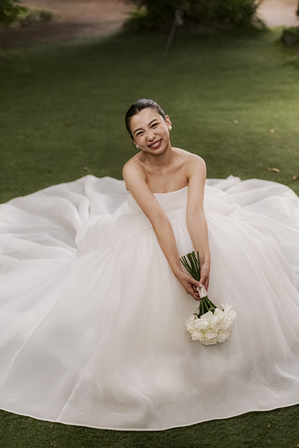 アムサーラのウェディングドレスを身に纏い、白いブーケを手に、優しく微笑むご新婦様。