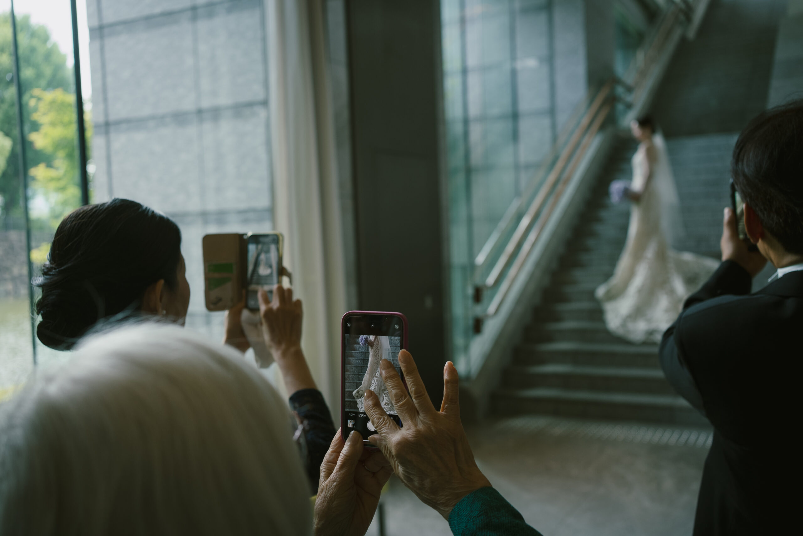 たっぷりと自然光が差し込み上質さを叶えることができる結婚式会場、パレスホテル東京にて結婚式を挙げられたご新郎ご新婦様をゲストの方が撮影されるご様子