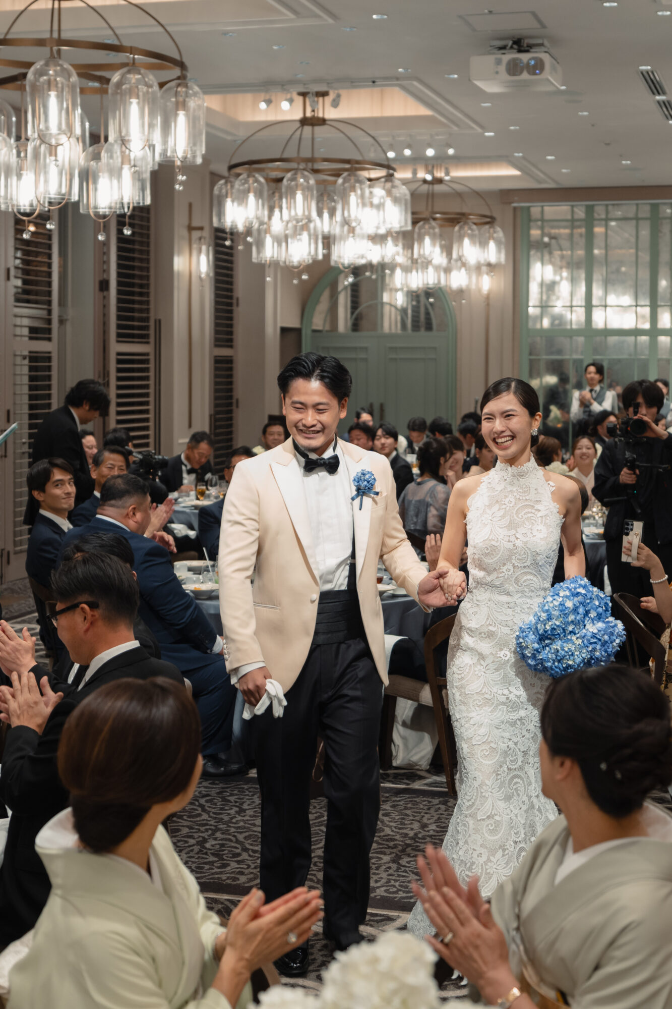 パーティーシーンでオスカーデラレンタのレースマーメイドを纏い、花嫁様らしいスタイルで結婚式を過ごされたご新婦様と、ホワイトジャケットを纏い新婦様をエスコートされるご新郎様