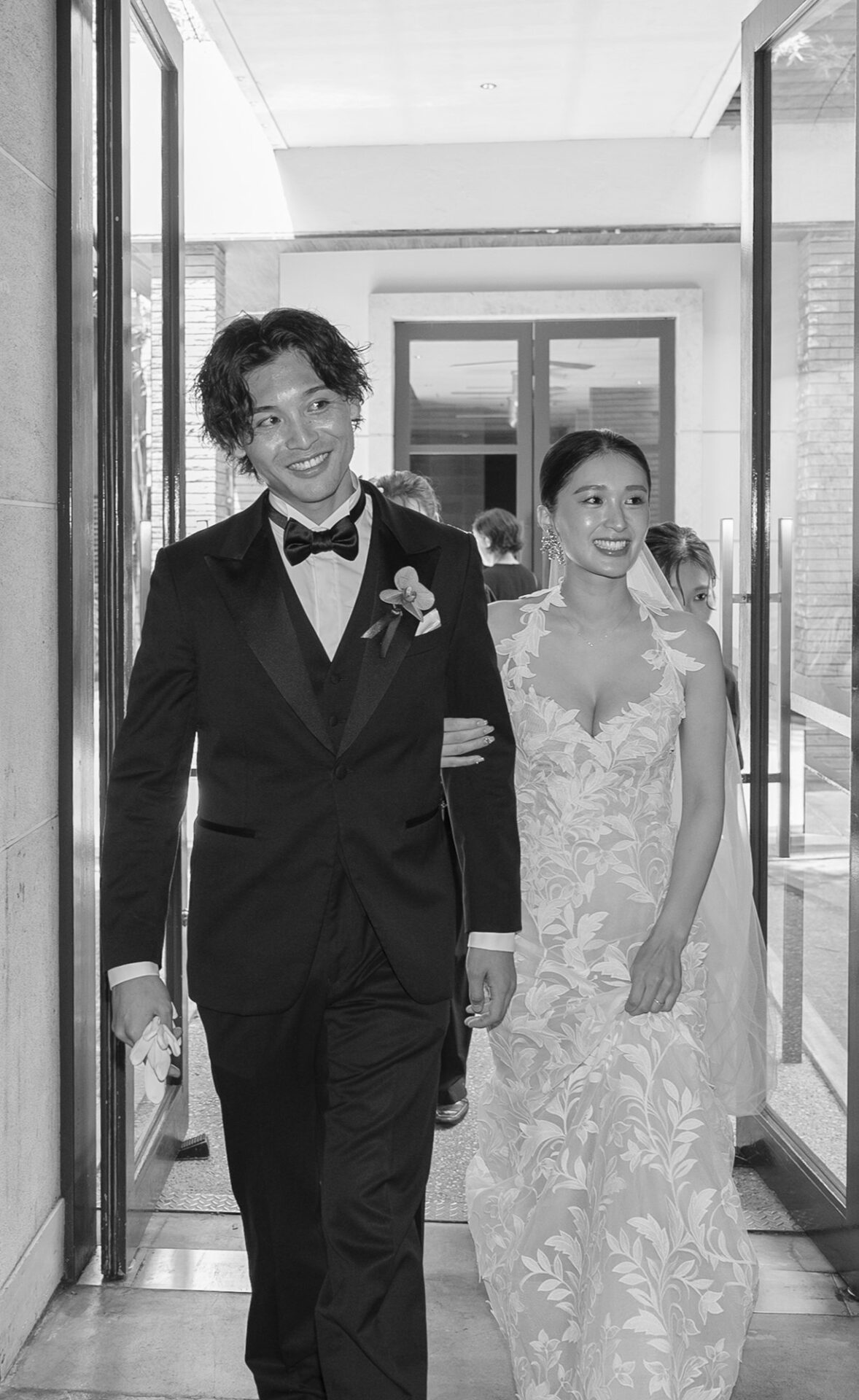 トリート福岡で人気のオスカー デ ラ レンタを身に纏い、披露宴会場へ移動するご新婦様とご新郎様のモノクロ写真。